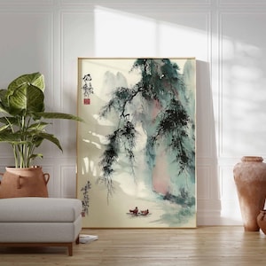 Puede incluir: Una pintura de paisaje enmarcada con un marco dorado. La obra representa una escena asi&aacute;tica tradicional con monta&ntilde;as, &aacute;rboles y figuras en un bote. La paleta de colores incluye tonos de verde, azul y beige. Una gran planta en maceta y una otomana gris est&aacute;n frente a la pintura.