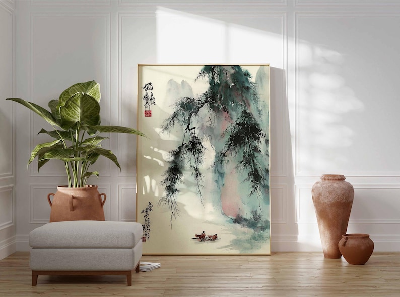 Puede incluir: Una pintura de paisaje enmarcada con un marco dorado. La obra representa una escena asi&aacute;tica tradicional con monta&ntilde;as, &aacute;rboles y figuras en un bote. La paleta de colores incluye tonos de verde, azul y beige. Una gran planta en maceta y una otomana gris est&aacute;n frente a la pintura.