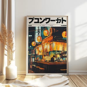 May include: Framed art print depicting a Japanese restaurant at night. The artwork shows a bar with a person behind it, lit by hanging lanterns and warm lighting. The print includes Japanese text.