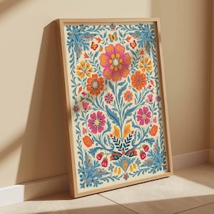 Op de afbeelding: Een ingelijst print met een kleurrijk bloemenontwerp. De bloemen zijn roze, oranje, geel en blauw. De achtergrond is cr&egrave;mekleurig.