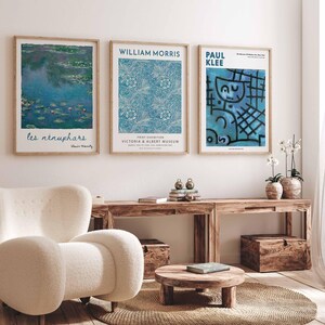 May include: Three framed art prints displayed on a white wall. The prints showcase artwork by Claude Monet, William Morris, and Paul Klee. The Monet print shows water lilies, the Morris print has a blue floral pattern, and the Klee print is abstract.