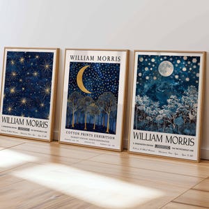 Op de afbeelding: Drie ingelijste posters met een blauw en gouden ontwerp met een halve maan en sterren. De posters zijn getiteld "William Morris" en adverteren voor een "Cotton Prints Exhibition".