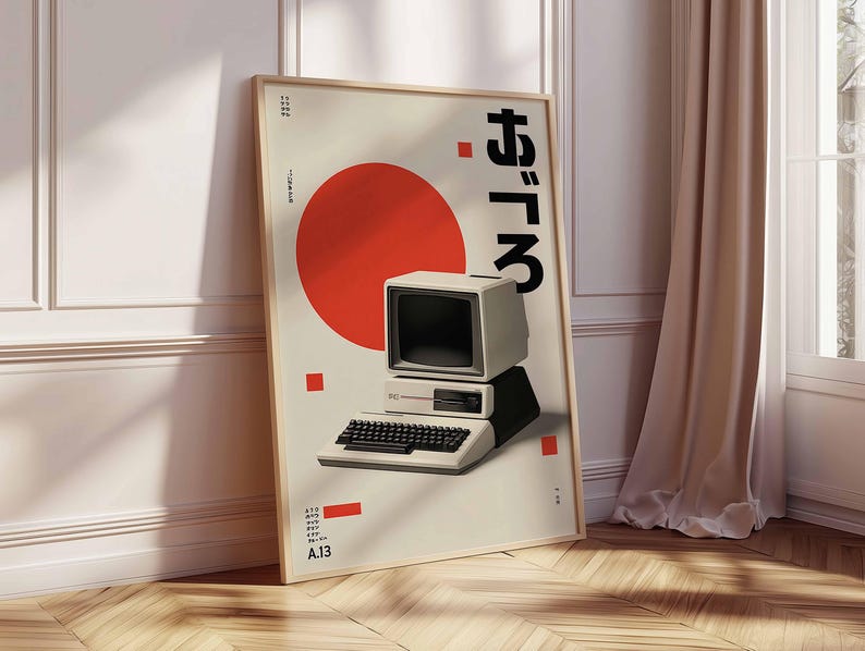 Puede incluir: Un p&oacute;ster enmarcado con un dise&ntilde;o de ordenador retro. La obra de arte incluye un c&iacute;rculo rojo, texto japon&eacute;s y un ordenador vintage con teclado. El p&oacute;ster est&aacute; sobre un fondo crema con un marco de madera.