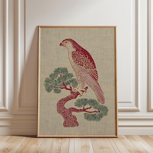 Puede incluir: Impresión artística enmarcada que representa un halcón rojo posado en un árbol estilizado con follaje verde. La obra de arte está sobre un fondo texturizado neutro, con un marco de madera. La impresión tiene una estética vintage.