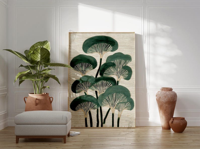 May include: A large framed art print featuring a stylized botanical design of dark green mushroom-like shapes on a beige background. The artwork is displayed in a room with a potted plant, a gray ottoman, and terracotta vases.