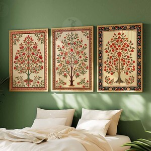 May include: Three framed prints of stylized floral trees with red flowers and green leaves on a cream background. The frames are gold with a black and red border.
