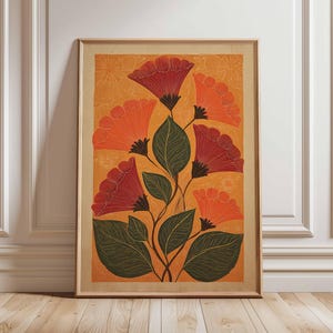 May include: Framed floral art print featuring stylized red and orange flowers with green leaves against an orange background. The artwork is in a wooden frame and leans against a white wall and wooden floor.