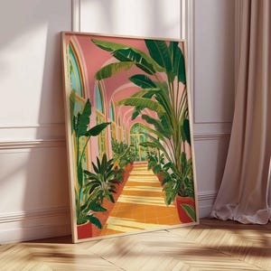 May include: A framed art print depicts a sunlit botanical scene. The artwork showcases a long corridor with arched windows, lined with potted plants and lush green foliage. The walls are a soft pink, and the floor is a warm orange hue. The frame is a light wood color.