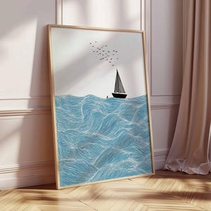 May include: A framed art print featuring a minimalist illustration of a sailboat on blue waves. The artwork includes a black sailboat, a flock of birds, and a light wood frame. The waves are detailed with white lines.