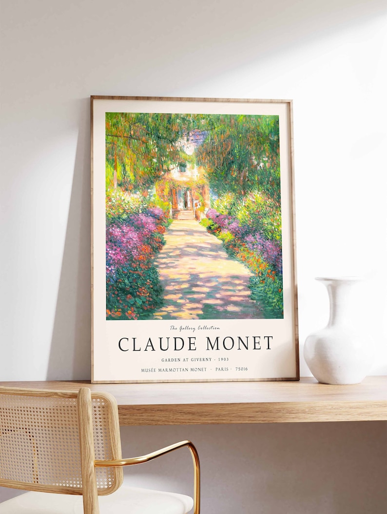 May include: A framed art print of a painting by Claude Monet titled "Garden at Giverny". The painting depicts a path lined with colorful flowers leading to a house in the distance. The print includes the artist's name, the title of the painting, and the location of the original artwork.