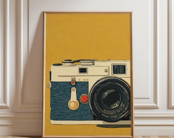 May include: A framed art print featuring a vintage camera illustration. The camera has a cream-colored body with a dark blue side panel and a large black lens. The background is a solid mustard yellow.