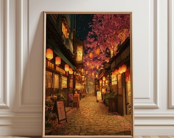 May include: Framed print of a Japanese street scene at night. The artwork shows a cobbled street with shops lit by lanterns and cherry blossom trees. The colour scheme is warm, with orange, brown, and pink hues. The print is in a wooden frame.