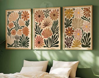 May include: Three framed prints with a floral design. The prints feature a pattern of pink, orange, and green flowers and leaves on a cream background.