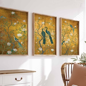 May include: Three framed prints with a gold background and a floral design. The prints feature birds and flowers in shades of blue, green, and white.