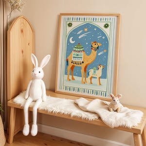 May include: A framed print featuring a camel and a smaller animal against a blue night sky with stars and a crescent moon. A white stuffed rabbit sits on a wooden bench with a faux fur runner, alongside a smaller rabbit toy.