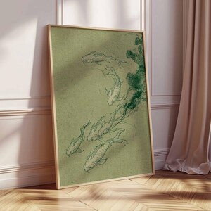 May include: A framed print featuring a sketch of koi fish in shades of green. The artwork is set against a muted green background, with the fish gracefully depicted. The frame is a light wood color, adding a natural touch to the piece.