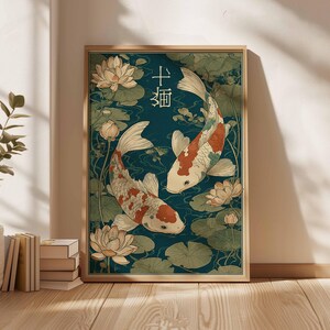 May include: Framed art print featuring two koi fish swimming in a pond with lily pads and lotus flowers. The artwork has a teal background and a wooden frame. The Japanese characters are visible in the upper right corner.