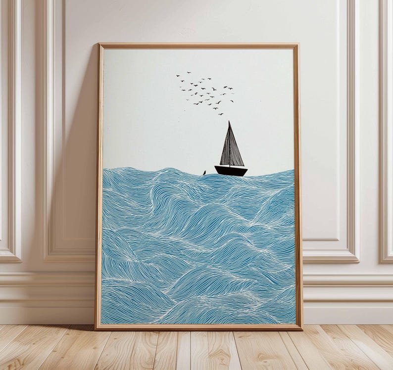 May include: Framed art print featuring a sailboat on a wavy sea. The waves are blue with white lines, and the boat is black with a triangular sail. A flock of birds flies above the boat, set against a white background.