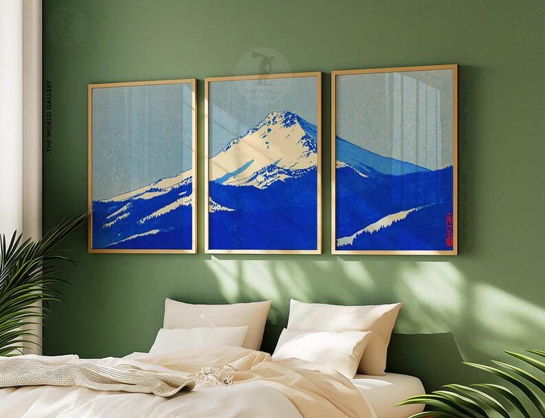 K&ouml;nnte beinhalten: Drei gerahmte Kunstdrucke, die eine Berglandschaft in Blau- und Wei&szlig;t&ouml;nen zeigen. Das Kunstwerk hat eine Vintage-&Auml;sthetik mit einem goldenen Rahmen. Die Drucke werden &uuml;ber einem Bett mit wei&szlig;er Bettw&auml;sche ausgestellt.