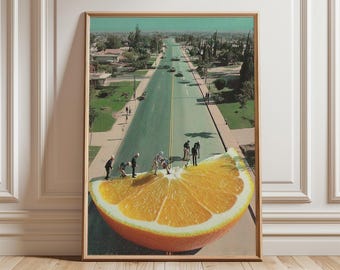 May include: Framed art print featuring a surreal collage. A slice of orange is juxtaposed with a street scene, with miniature figures interacting on the fruit. The artwork has a vintage aesthetic, with a color palette of orange, green, and brown.