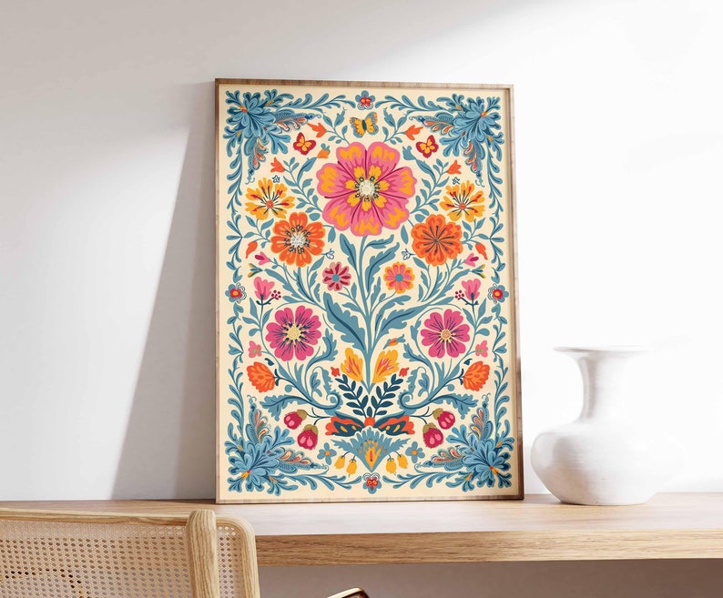Op de afbeelding: Een digitale print met een kleurrijk bloemenpatroon met roze, oranje, gele en blauwe bloemen op een cr&egrave;mekleurige achtergrond. De print is ingelijst in een licht houten lijst.