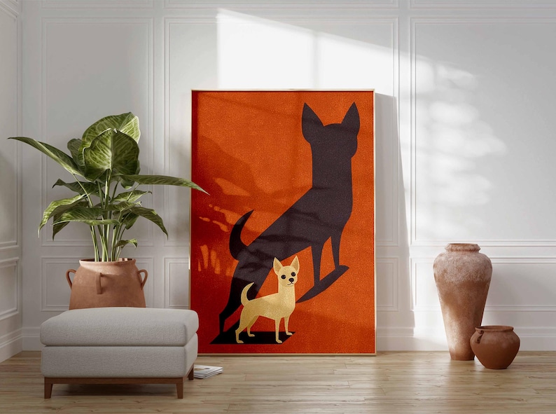 May include: A framed art print featuring a stylized illustration of a Chihuahua dog with a dark silhouette of a larger dog on an orange background. The artwork is displayed in a room with a plant, ottoman, and decorative vases.