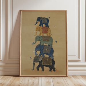 May include: Framed print depicting five elephants, stacked, in shades of blue, gold, and grey. Each elephant has a decorative saddle. Small birds are scattered around the elephants against a beige background.