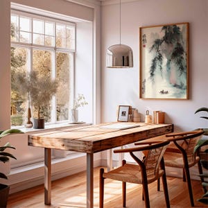 Puede incluir: Una habitaci&oacute;n luminosa con un escritorio de madera y dos sillas. Una pintura enmarcada de un paisaje cuelga de la pared. Una gran ventana ofrece una vista de &aacute;rboles y follaje. Una l&aacute;mpara colgante plateada cuelga sobre el escritorio.