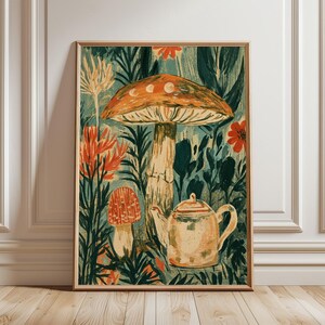 Può includere: Una stampa artistica rettangolare in una cornice di legno raffigurante un grande fungo arancione con fasi lunari sul cappello, un fungo più piccolo a pois rossi, una teiera chiara e varie piante verdi e fiori arancioni su uno sfondo verde acqua scuro.