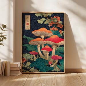 May include: Framed art print with a stylized illustration of mushrooms in red, orange, and pink against a dark blue background. Green foliage and orange flowers surround the mushrooms. The print has Japanese text in a vertical rectangle.