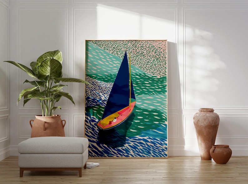 May include: A framed art print showing a sailboat on a sea of blue and green. The sailboat has a dark blue sail, a pink and yellow hull, and is set against a backdrop of stylized waves. The artwork is displayed in a room with a plant, ottoman, and decorative vases.