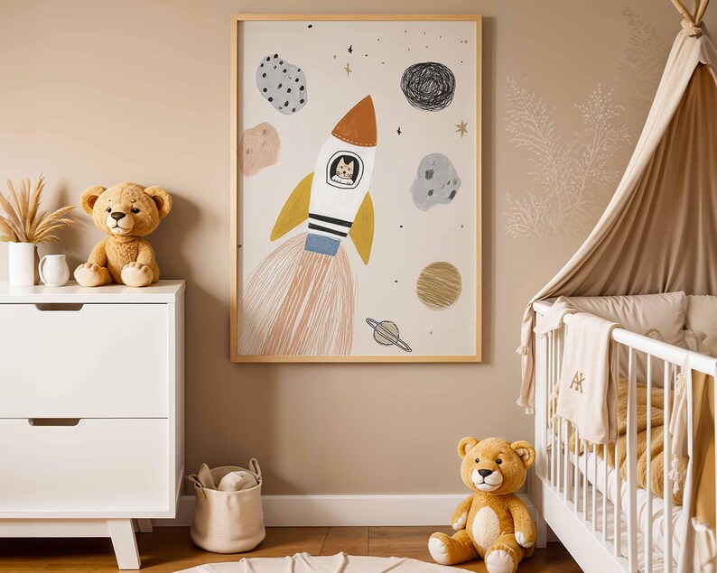 May include: A framed art print featuring a whimsical rocket ship with a cat in the cockpit, surrounded by planets and stars. The artwork is in a child's bedroom, alongside a white dresser, teddy bears, and a crib.
