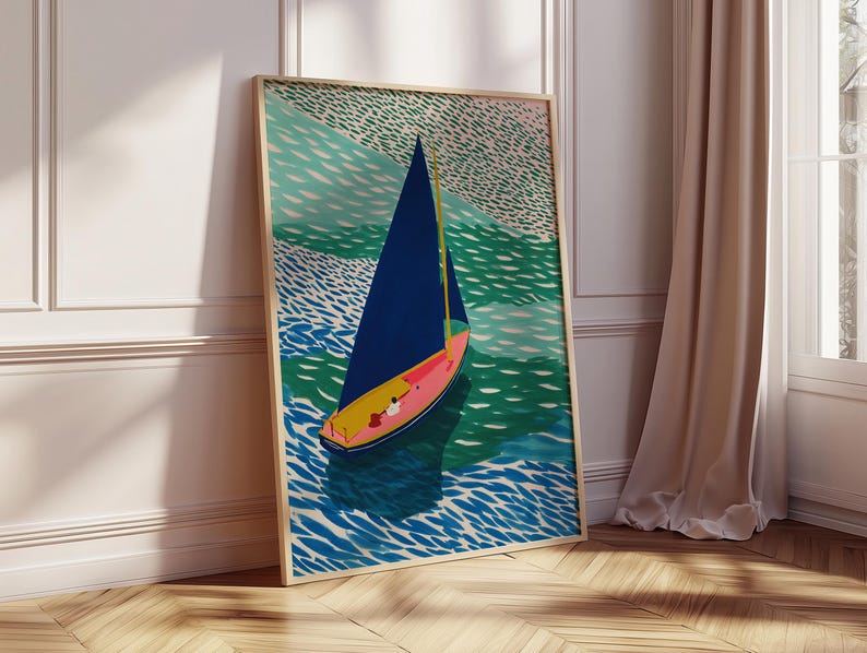 May include: A framed art print depicting a sailboat on water. The boat has a blue sail and a yellow and pink hull. The water is shown in shades of blue and green, and the sky is a light green colour.