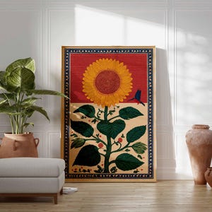 May include: A framed artwork featuring a large sunflower with a red background and a blue bird. The sunflower has yellow petals and a brown center. The artwork is displayed in a room with a plant, ottoman, and decorative vases.