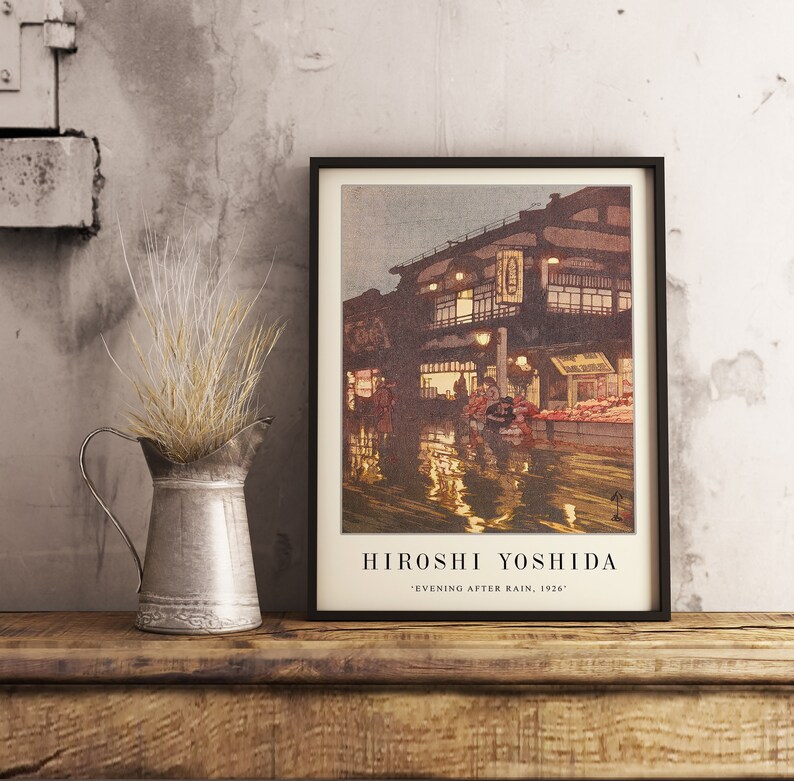 May include: A framed print of a painting by Hiroshi Yoshida titled "Evening After Rain, 1926". The painting depicts a street scene in Japan with buildings, people, and reflections in the water.