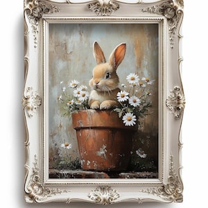 Könnte beinhalten: Ein weiß gerahmtes Gemälde eines braunen Kaninchens, das in einem Terrakotta-Blumentopf mit weißen Gänseblümchen sitzt. Der Hintergrund ist hellbraun und beige.