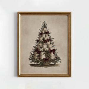 Può includere: Una stampa incorniciata raffigura un albero di Natale fatto con rotoli di carta igienica impilati. L'albero è adornato con fiocchi bordeaux e rametti verdi. L'opera d'arte ha un tono seppia ed è incorniciata in oro.