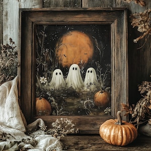 May include: A framed painting depicting three white ghosts standing in a dark, grassy field under a large orange moon. The scene includes two orange pumpkins in the foreground, silhouetted bats in the sky, and dark, weathered wooden framing.
