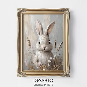 May include: A framed painting of a white rabbit with soft, fluffy fur, surrounded by delicate flowers and grasses. The rabbit has large, dark eyes and a sweet expression. The painting is set against a light blue background with subtle brushstrokes.