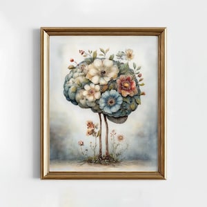 Puede incluir: Una impresión artística enmarcada con una ilustración en acuarela de un cerebro adornado con flores coloridas. La obra de arte tiene un marco dorado y representa un tema surrealista y botánico con un fondo azul claro y blanco.