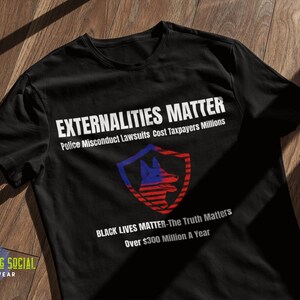 Puede incluir: Camiseta negra con texto blanco que dice "EXTERNALITIES MATTER" y "Police Misconduct Lawsuits Cost Taxpayers Millions". Debajo del texto hay un escudo rojo, blanco y azul con la cabeza de un perro dentro. Debajo del escudo hay más texto blanco que dice "BLACK LIVES MATTER-The Truth Matters" y "Más de 300 millones de euros al año".
