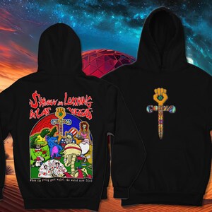 May include: Black hooded sweatshirt with a graphic print of a scene from the movie 'Fear and Loathing in Las Vegas'. The graphic features a group of cartoon characters playing cards around a table. The text 'Fear and Loathing in Las Vegas' is printed above the graphic. The text 'When the going gets weird, the weird turn pro' is printed below the graphic.