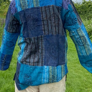 May include: A blue and black patchwork long-sleeved shirt with a variety of sun and floral designs.