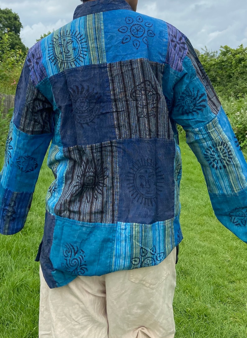 May include: A blue and black patchwork long-sleeved shirt with a variety of sun and floral designs.