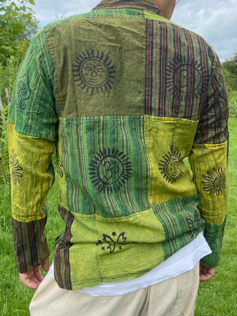 May include: A green and brown long-sleeved shirt with a patchwork design. The shirt features various sun and butterfly motifs.