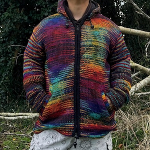 May include: A colourful striped hooded sweater with a zip closure. The sweater is made of a soft, knitted fabric and features a variety of colours, including red, orange, yellow, green, blue, and purple.
