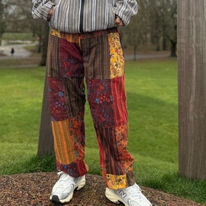 Könnte beinhalten: Patchwork-Hose in Braun, Rot, Orange und Gelb. Die Hose hat ein Blumenmuster und ist aus einem weichen, bequemen Stoff gefertigt.