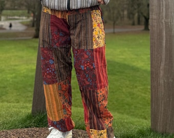 Peut inclure: Pantalon patchwork avec un motif brun, rouge, orange et jaune. Le pantalon a un motif floral et est fait d'un tissu doux et confortable.