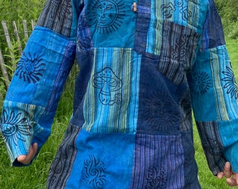 May include: A blue and black patchwork long-sleeved shirt with various printed designs, including suns, mushrooms, and swirls.