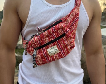May include: A red, orange, and yellow patterned fanny pack with a black zipper and a brown leather tag that says "Hemp Hemp".